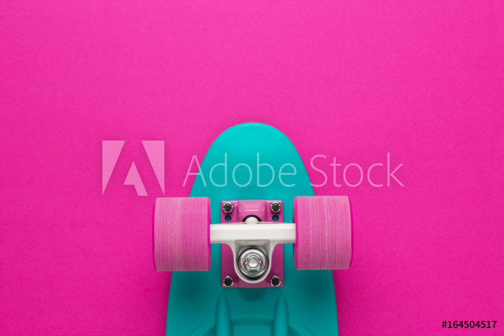plastic mini cruiser board on deep pink with background with copy space